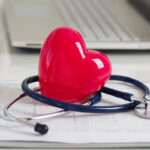 Read heart and stetoscope laying on cardiogram chart at doctor’s