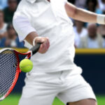 Male tennis player with forehand  racquet swing hitting ball