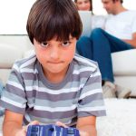 10234263-concentrated-boy-playing-video-games-lying-on-the-floor