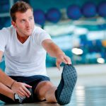 Biotonic-Vibe-Studio_10579646-man-at-the-gym-doing-stretching-exercises-and-smiling-on-the-floor