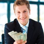 Total-Bank_10250154-junior-businessman-holding-dollars-and-smiling-at-the-camera