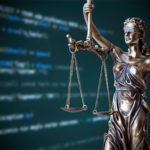 Justice statue with code on screen in background