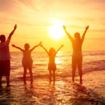 happy family watching the sunset on the beach