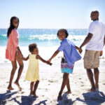 The ocean looks amazing. An african-american family enjoying a day at the beach together.