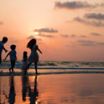 Silhouette family walking and playing at beach sunset with kids happy vacation concept