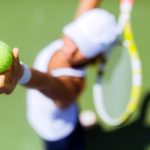 Beautiful female tennis player serving