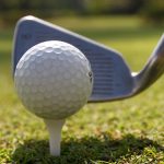 Golf balls and Driver on green grass background