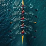 Beautiful women’s rowing team on blue water. Teamwork concept