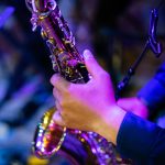 A close up picture of a artist is playing saxophone in the churc